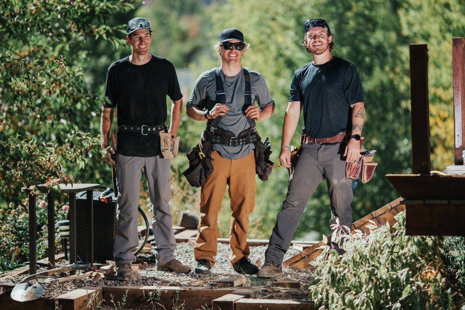 A trio of trade professionals with Elevated Independent Energy pose together in Truewerk workwear at a jobsite.