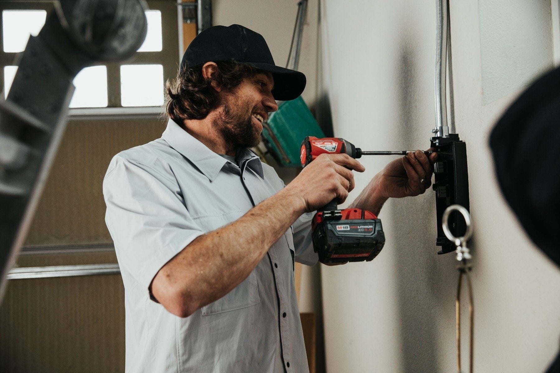 An electrician wearing Truewerk workwear installs a box into the wall. 